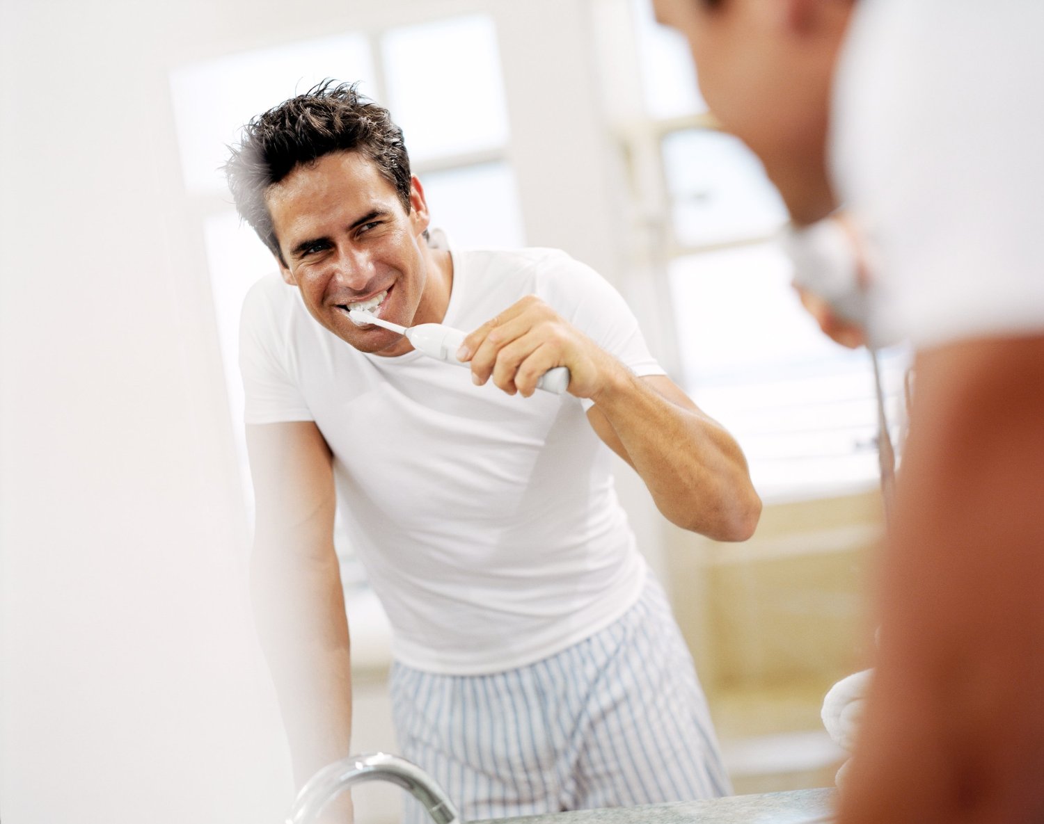 Man teeth brushing with electric toothbrush